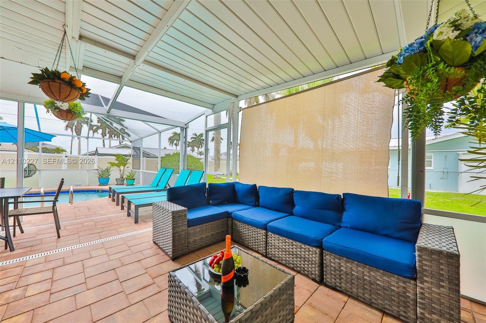 Screened-in lanai featuring paver flooring, an integrated pool, and a white aluminum frame
