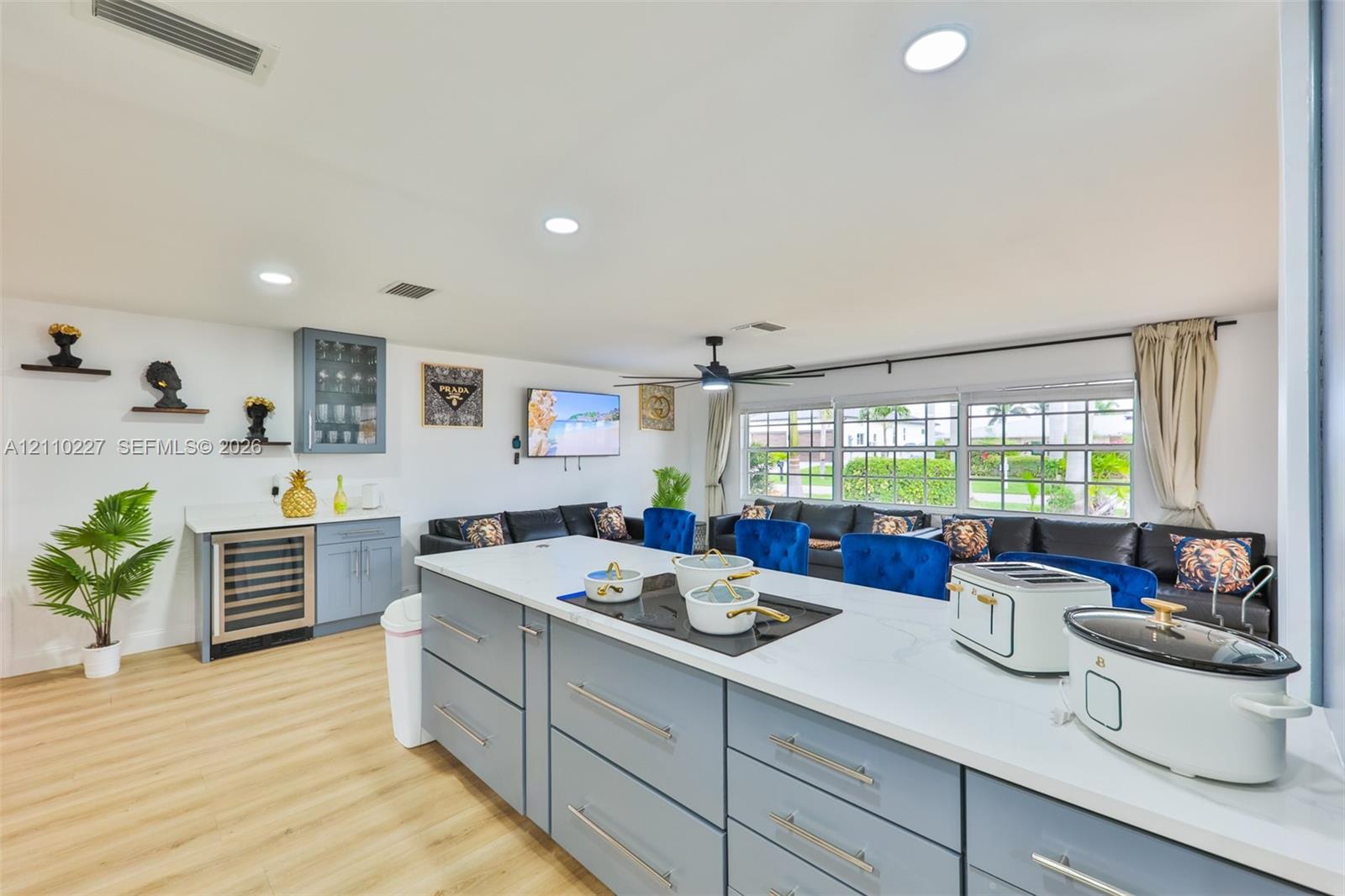 Kitchen featuring light blue cabinetry, stone-finish countertops, built-in under-counter beverage refrigerator, recessed lighting, and wood-finish flooring