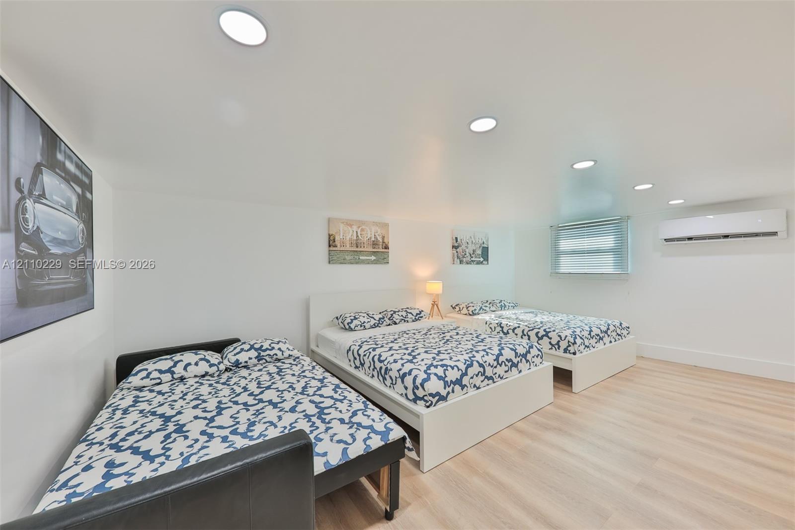 Neutral-toned wood-finish flooring, recessed lighting, and wall-mounted climate control unit