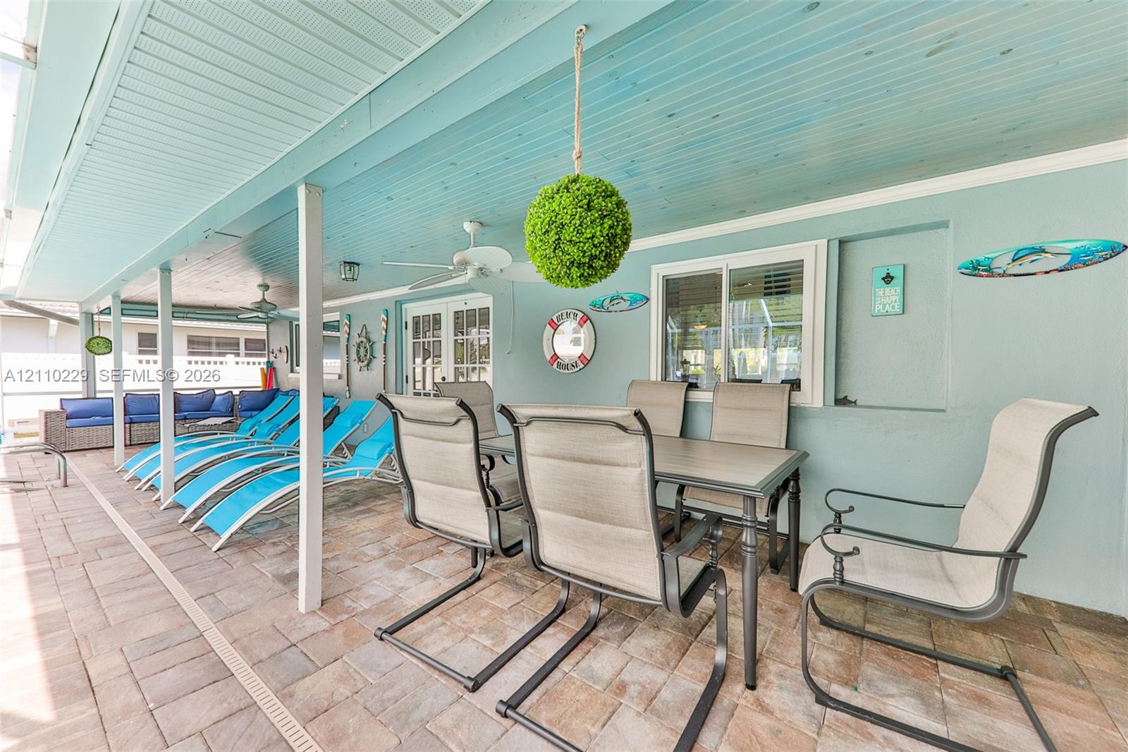 Covered patio featuring a paver floor, beaded wood-finish ceiling, and integrated ceiling fans