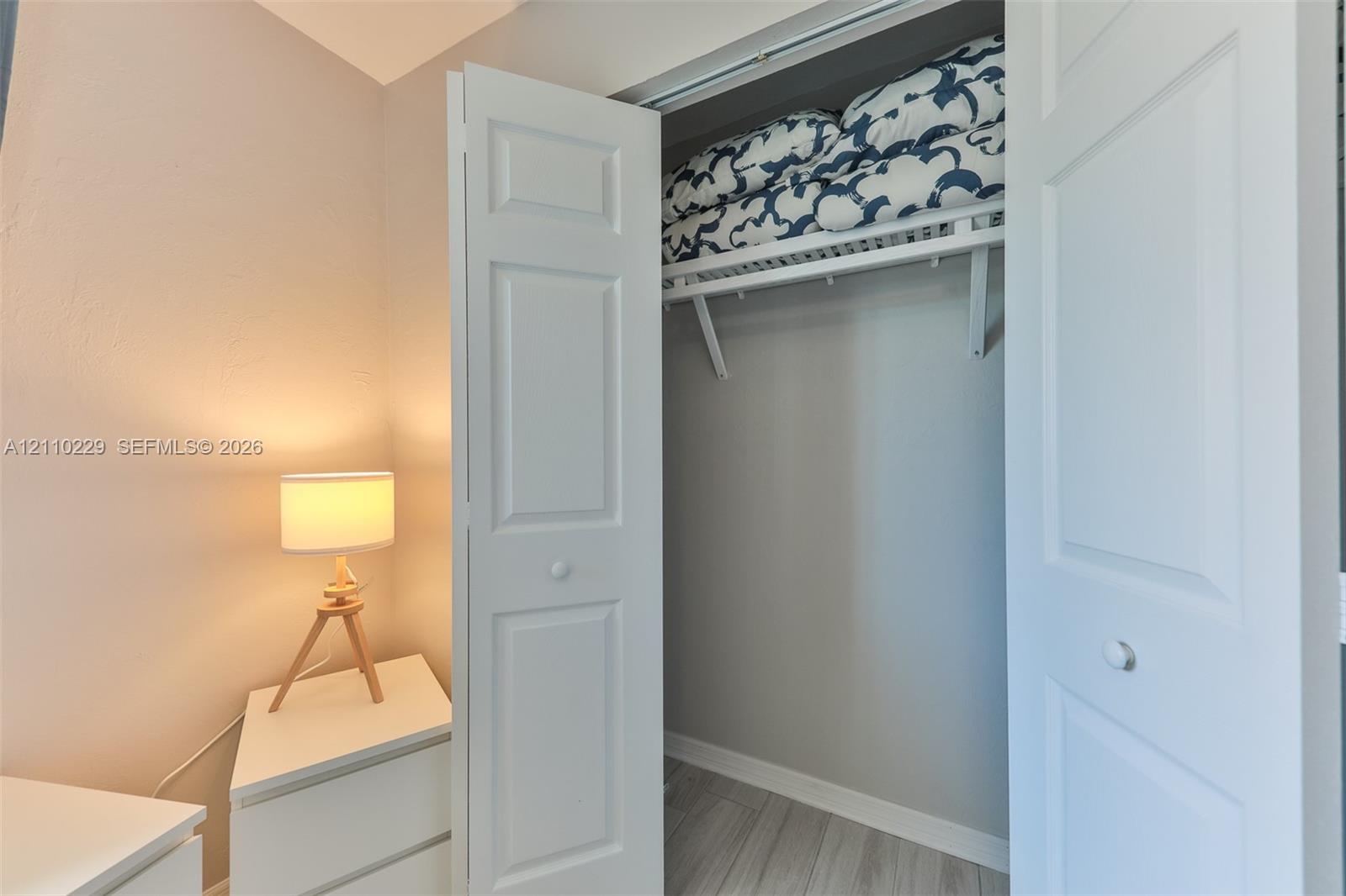 Closet featuring white paneled bifold doors and integrated upper shelving