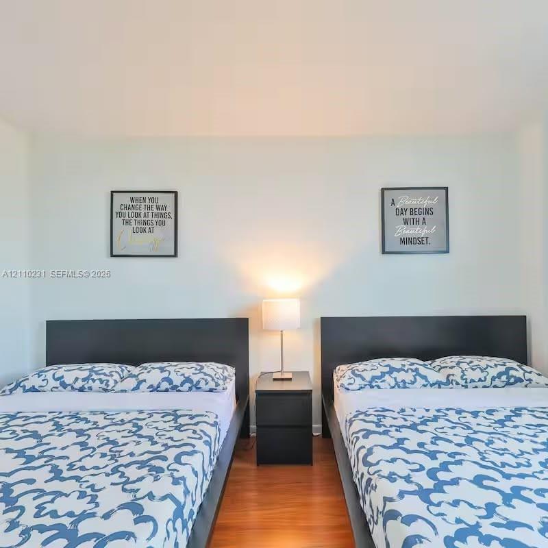 Room featuring smooth-finish walls and wood-finish flooring Room featuring smooth-finish walls and wood-finish flooring