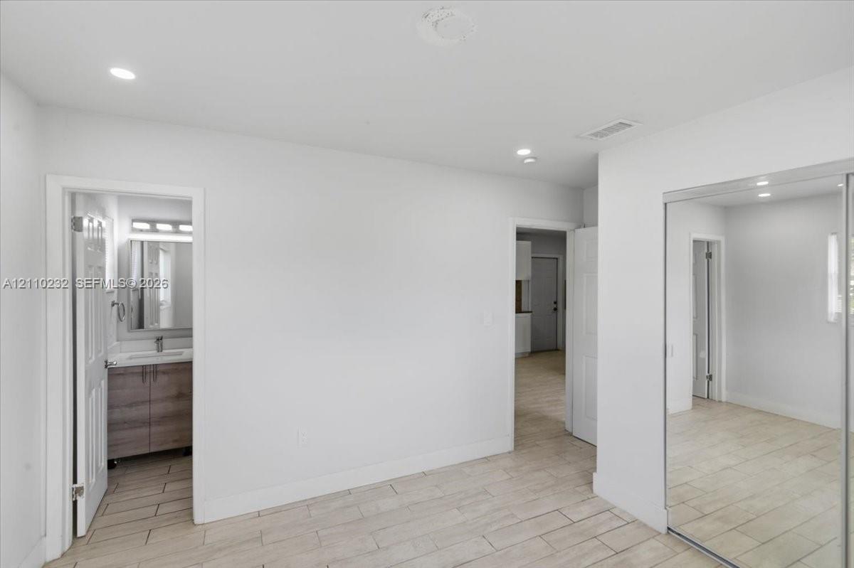 Interior space featuring tile flooring, recessed lighting, and mirrored closet doors