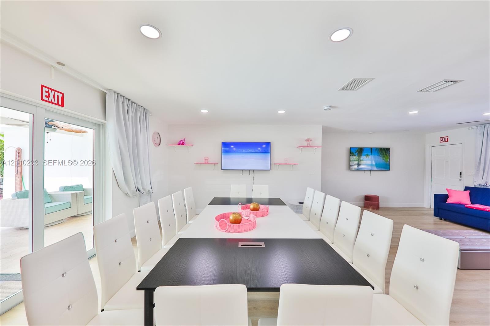 Open-concept space featuring recessed ceiling lighting, light-toned wood-finish flooring, and glass sliding doors