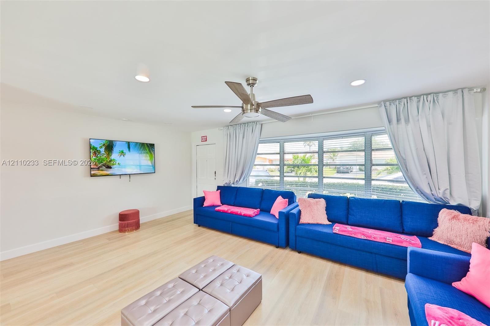 Living area featuring light-toned wood-finish flooring, recessed lighting, and a multi-blade ceiling fan
