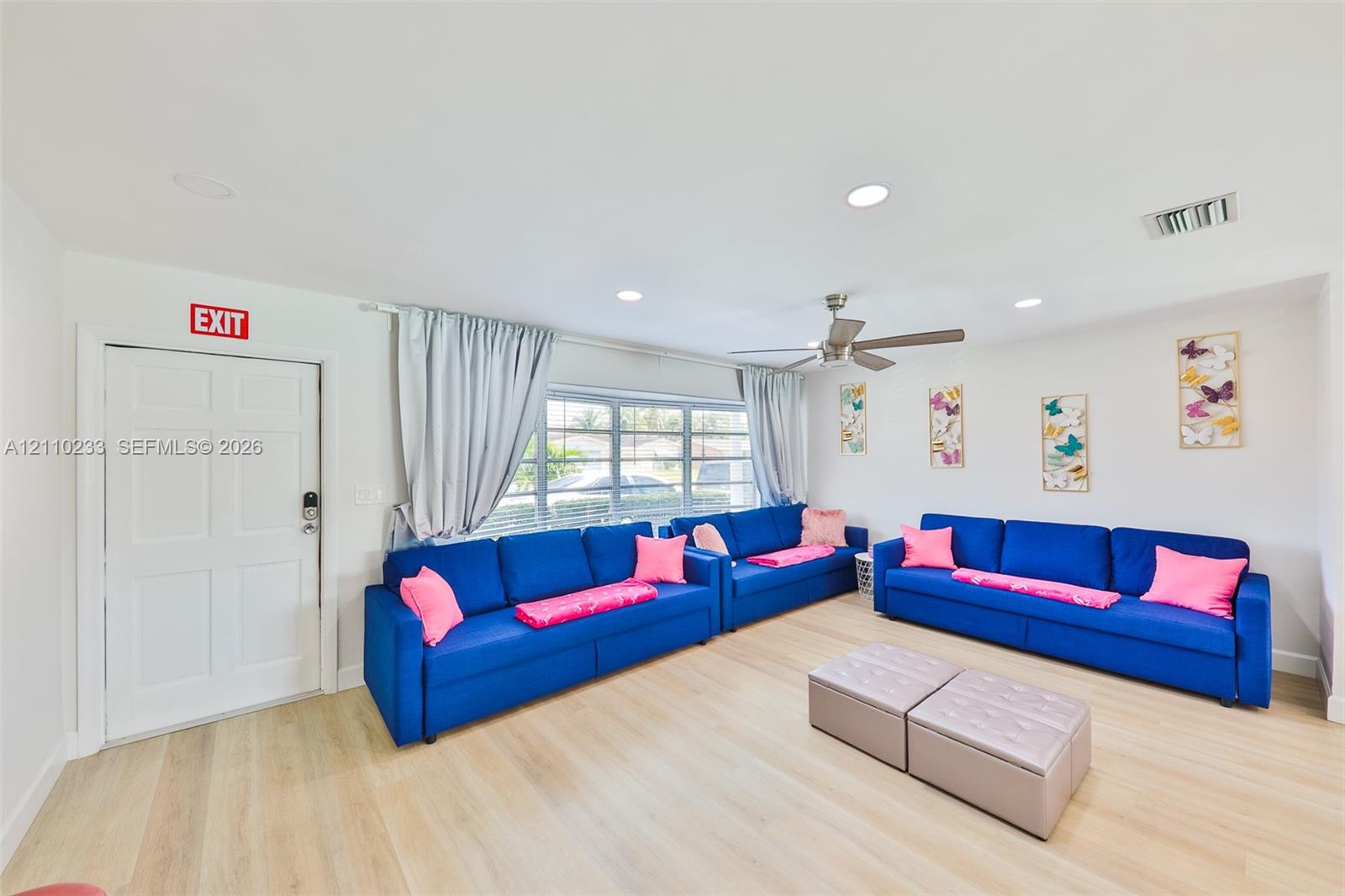 Neutral interior featuring light-tone wood-finish flooring, recessed lighting, a ceiling fan, and multi-pane windows