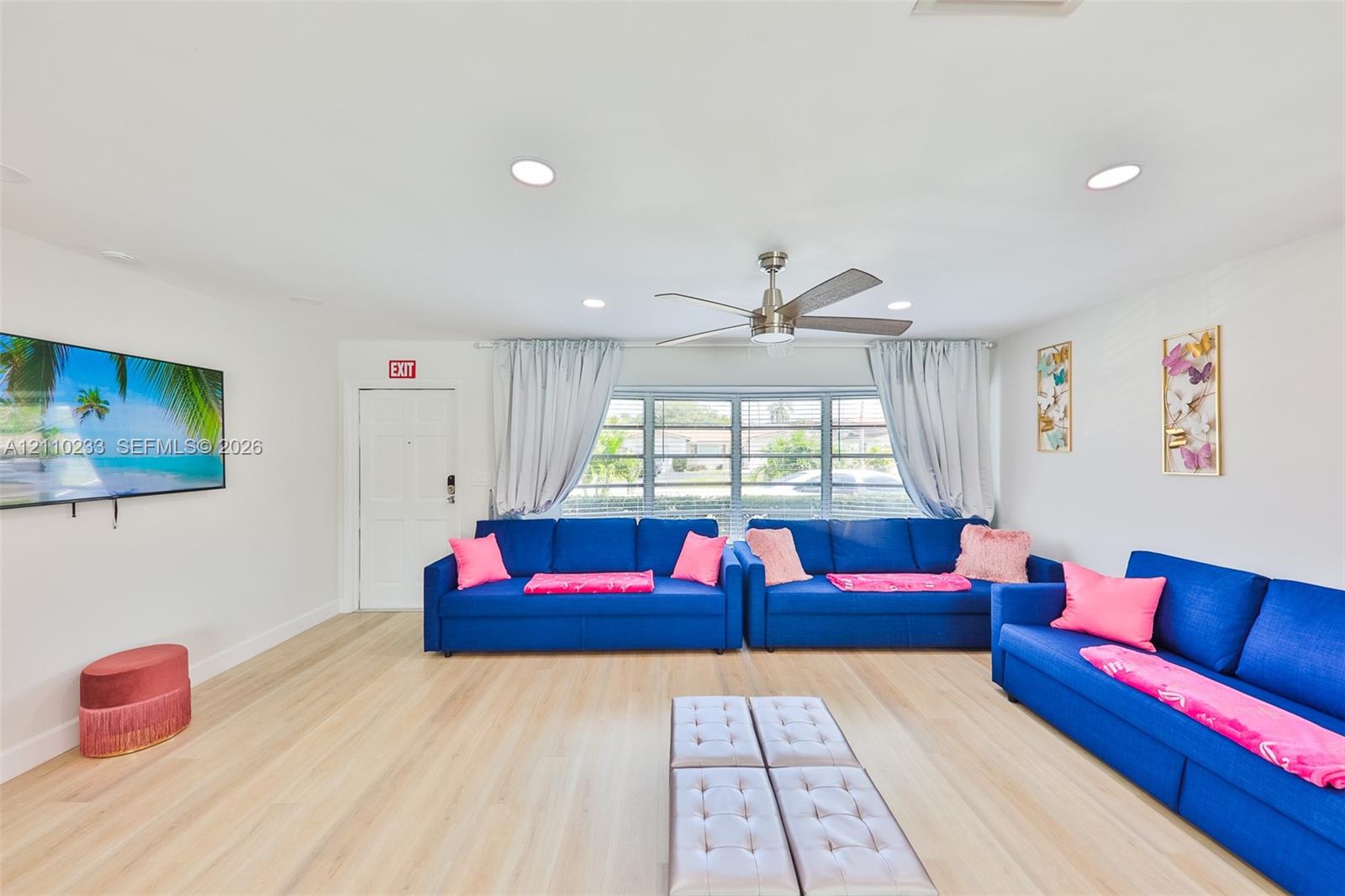 Living area featuring light-toned wood-finish flooring, recessed lighting, and a multi-blade ceiling fan