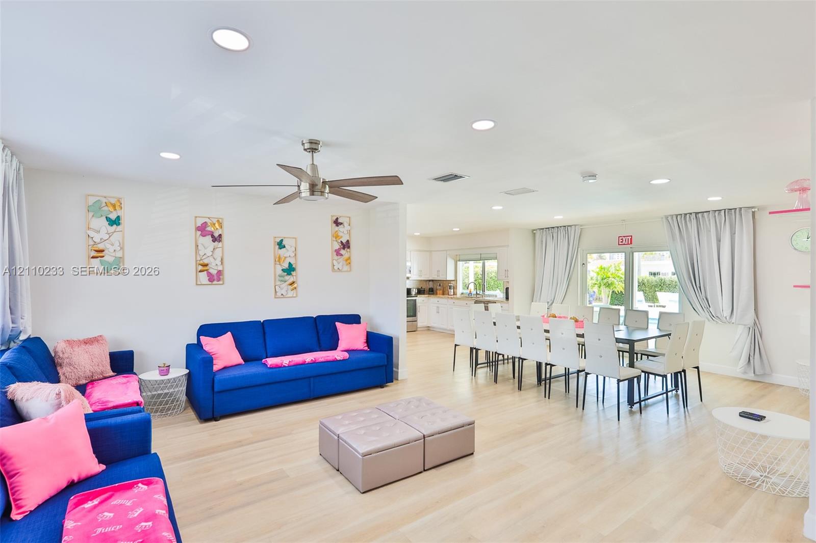 Open-concept floor plan featuring light-toned wood-finish flooring, recessed lighting, and a brushed-nickel ceiling fan