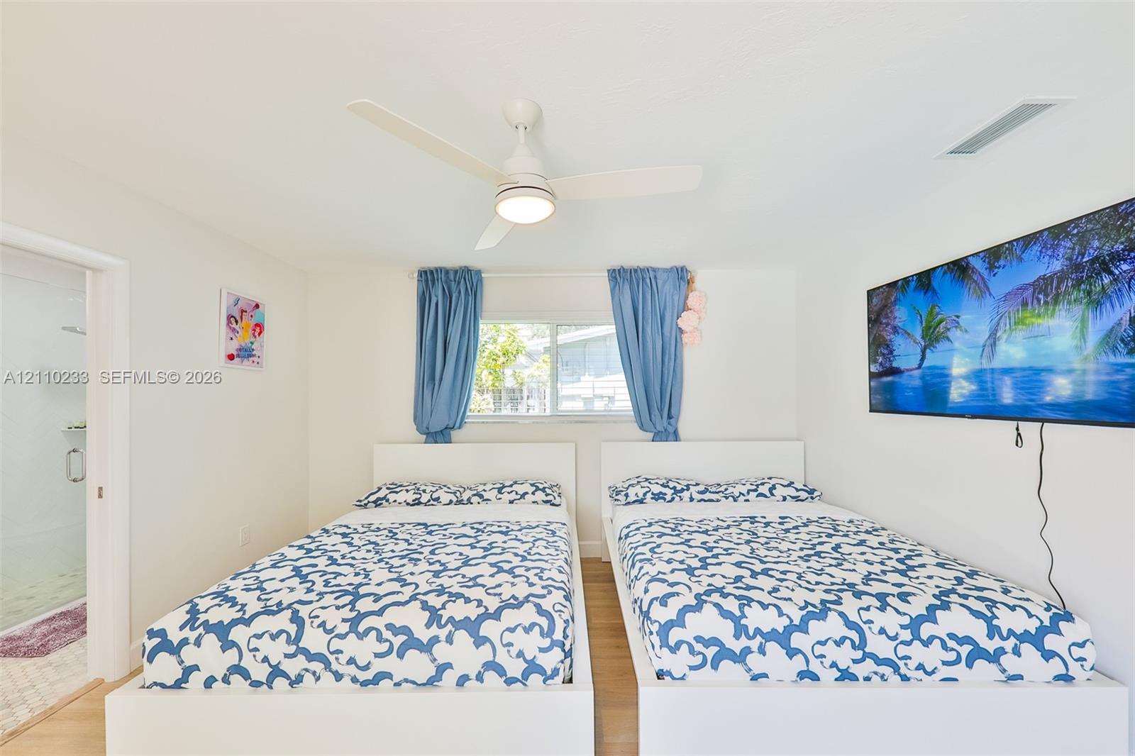 Interior space featuring a white ceiling fan with integrated lighting and wood-finish flooring