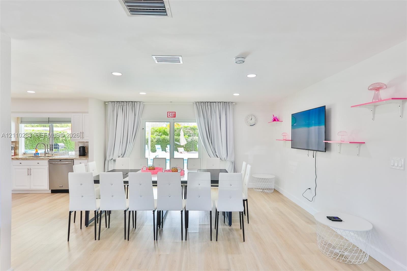 Open-concept interior featuring wood-finish flooring, recessed lighting, and white cabinetry