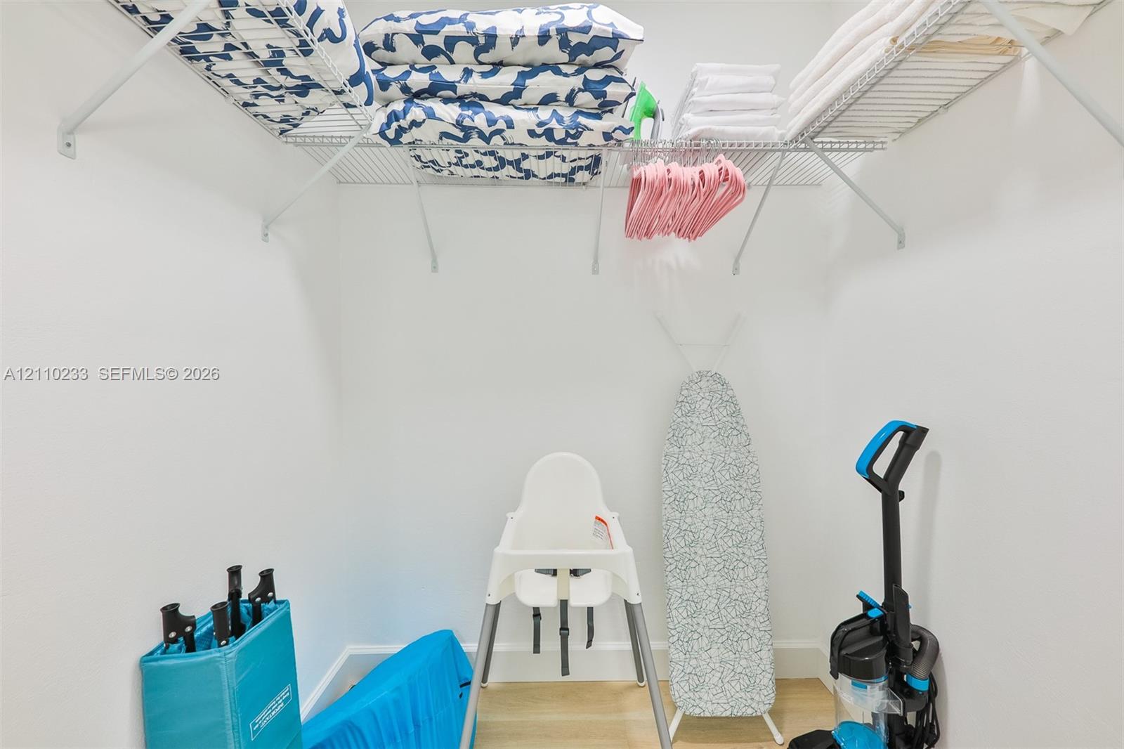 Storage space featuring wall-mounted wire shelving and neutral wall finishes