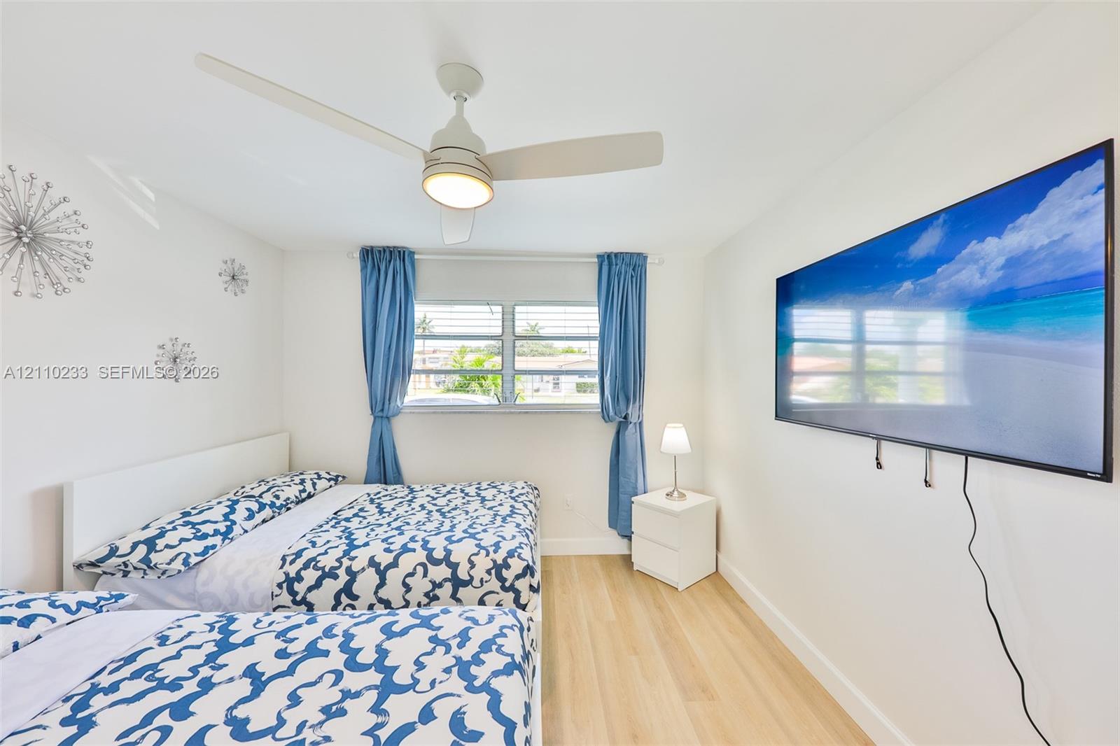 Light-toned wood-finish flooring, ceiling fan with integrated lighting, and horizontal sliding windows
