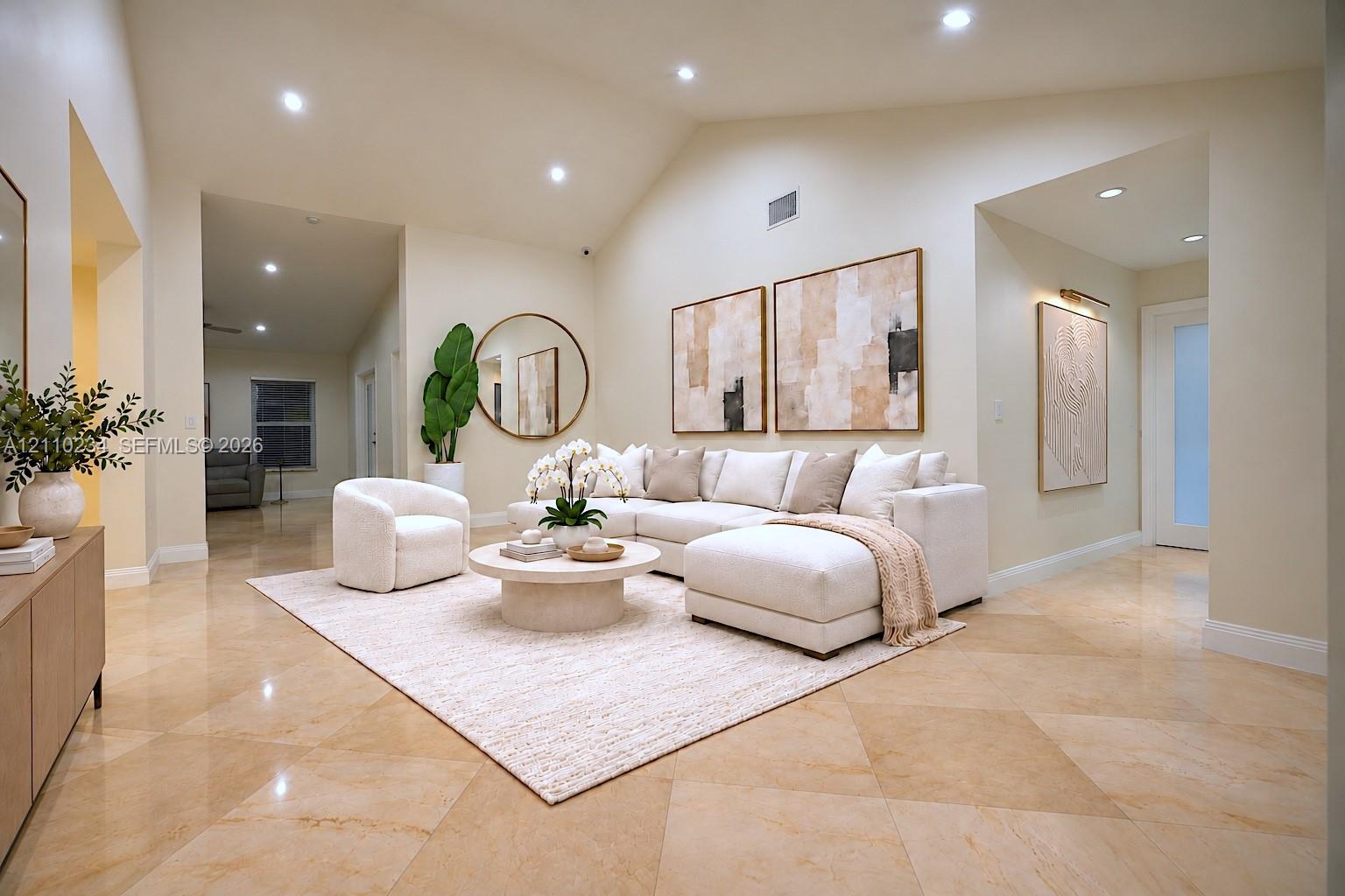 Expansive living area featuring vaulted ceilings, recessed lighting, and neutral stone-finish tile flooring