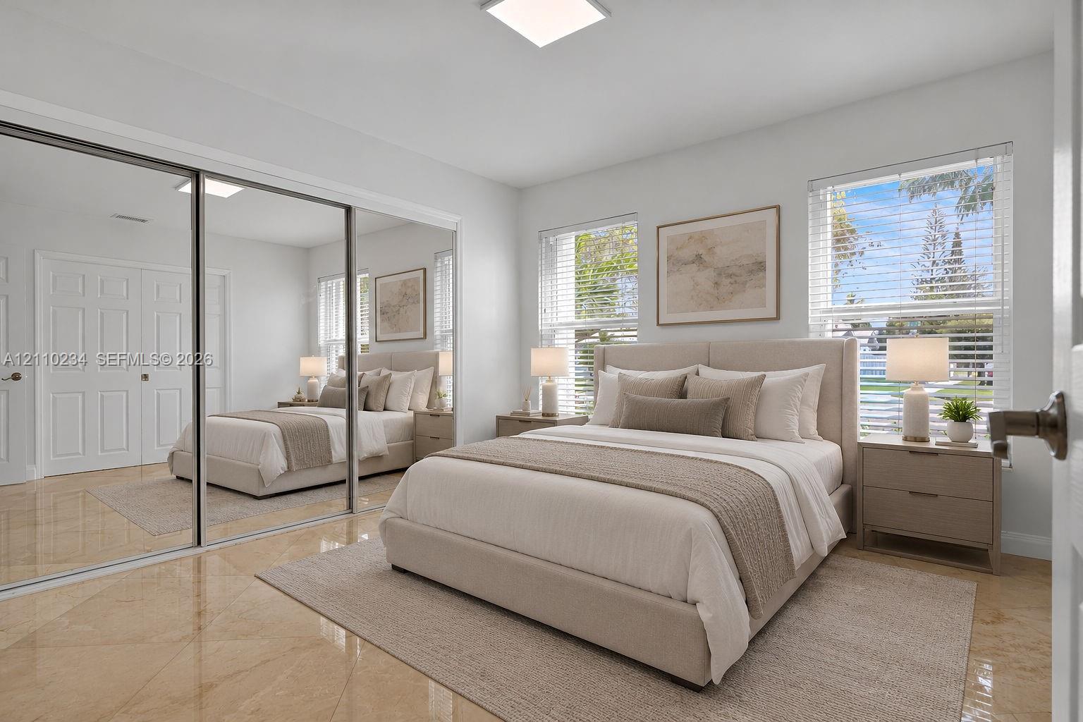 Bedroom featuring polished tile flooring, full-wall sliding mirrored closet doors, recessed ceiling lighting, and multiple windows with horizontal blinds
