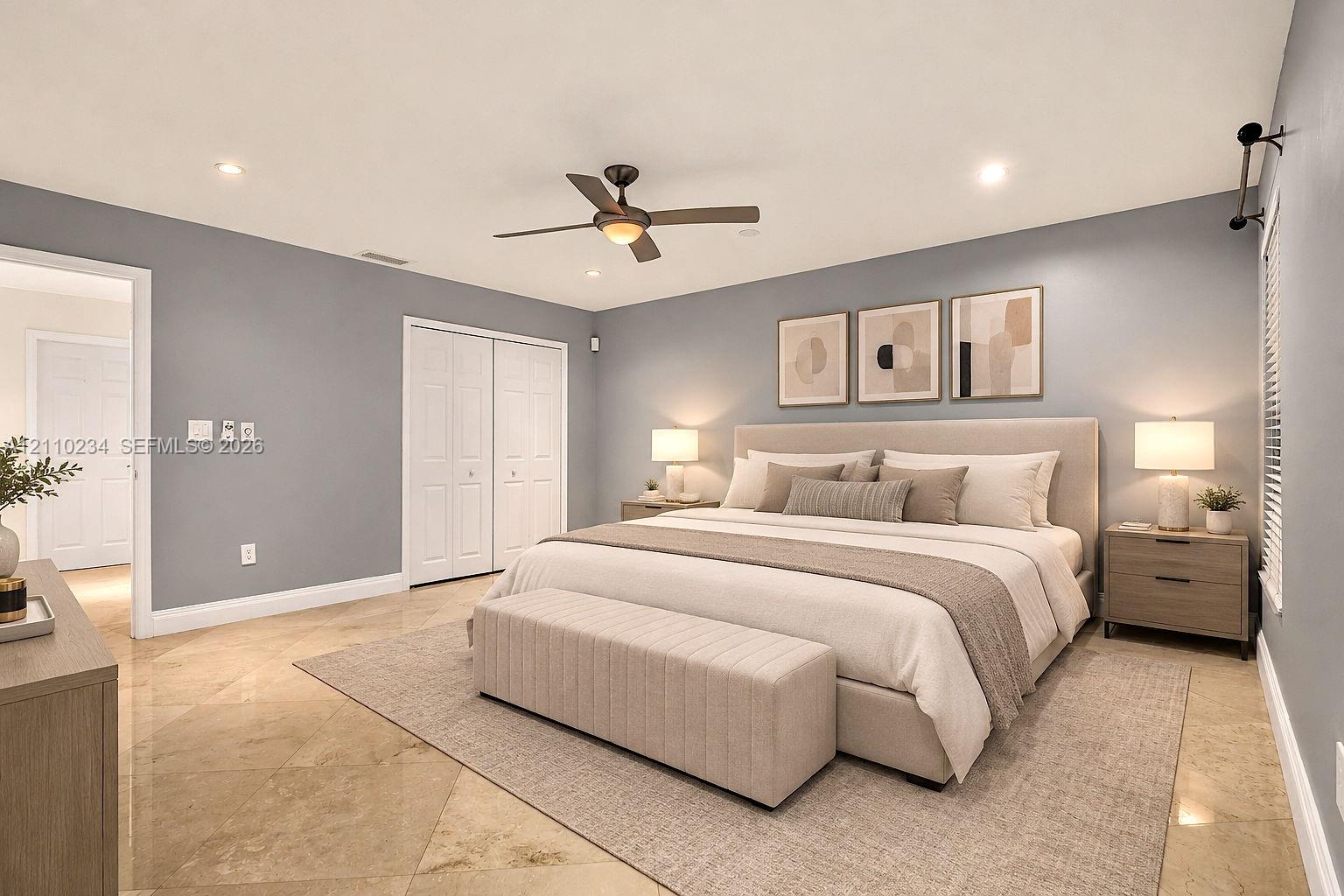 Spacious room featuring polished stone flooring, recessed lighting, a multi-blade ceiling fan, and double-door closet storage