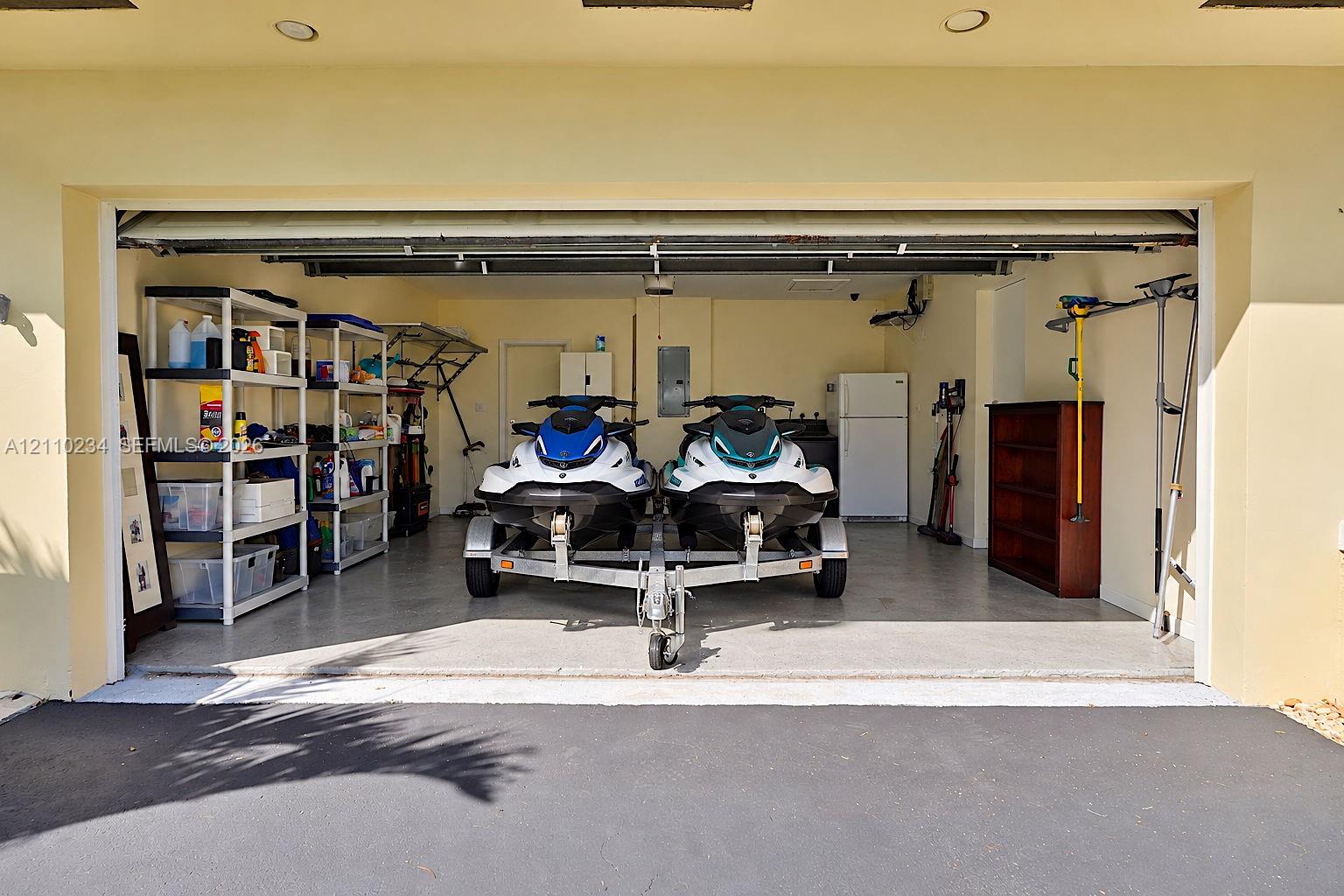Two-car garage featuring recessed lighting, a finished concrete floor, and an automatic roll-up door