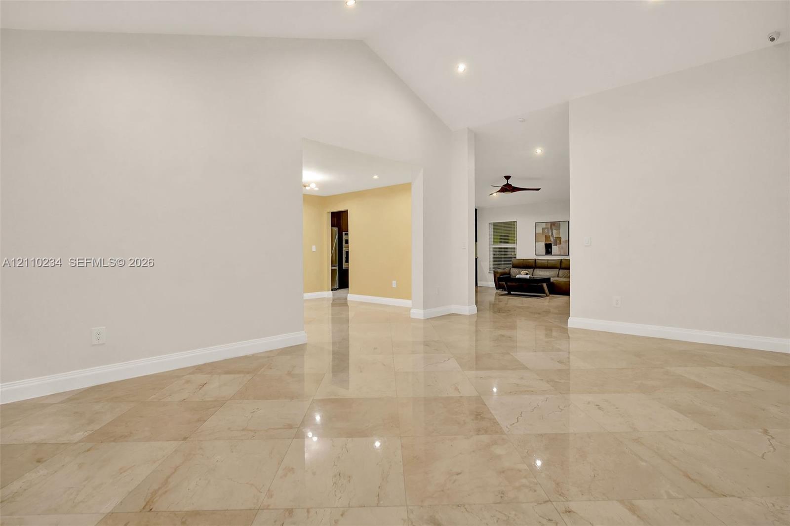 Vaulted ceilings featuring recessed lighting and polished stone-finish tile flooring