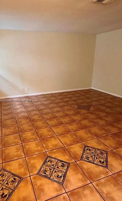 Interior room featuring large-format ceramic floor tiles with decorative inlaid tile medallions