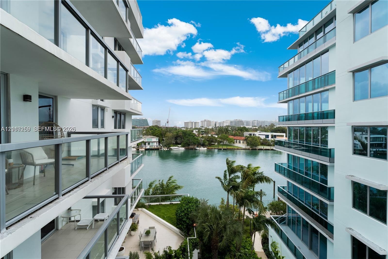 Modern high-rise architecture featuring glass-railed private balconies, floor-to-ceiling windows, and water frontage