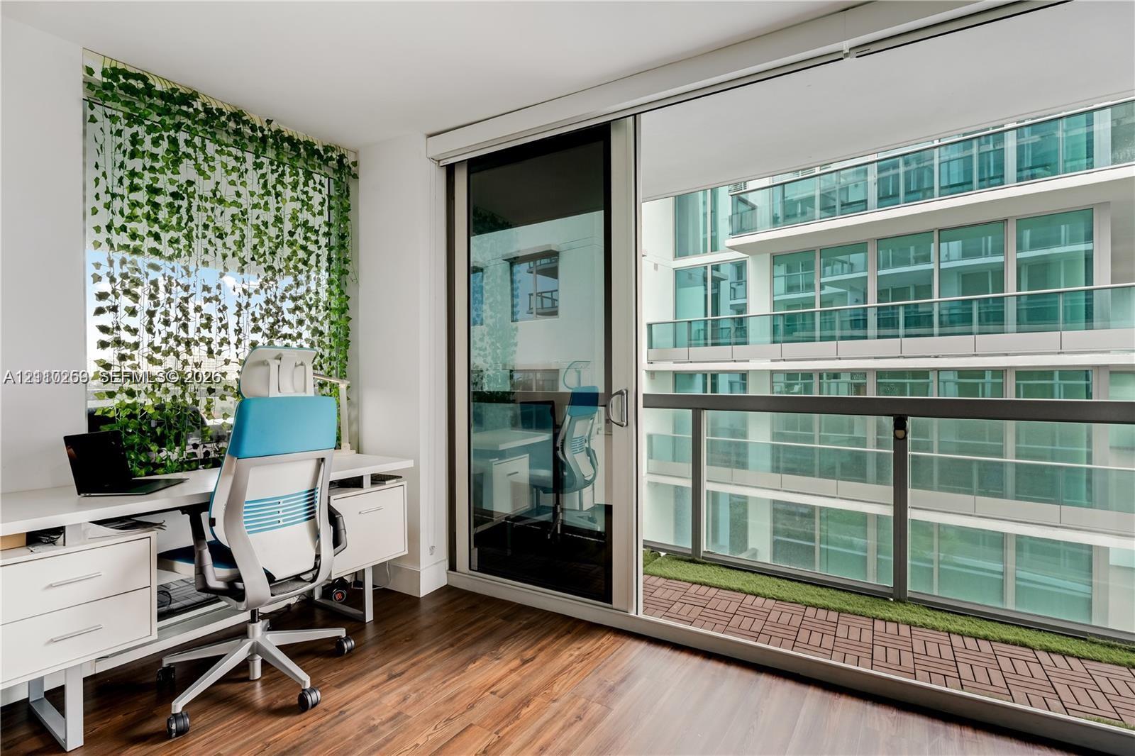 Wood-finish flooring, floor-to-ceiling glass sliding doors, and a private balcony with modular decking