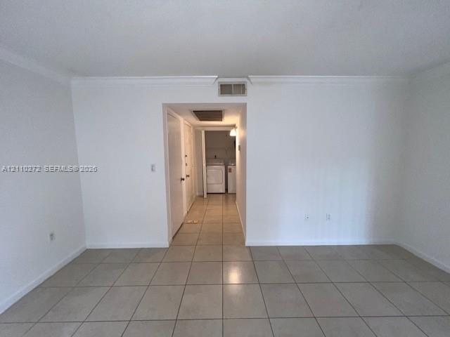 Neutral-toned tile flooring, crown molding, and painted interior doors
