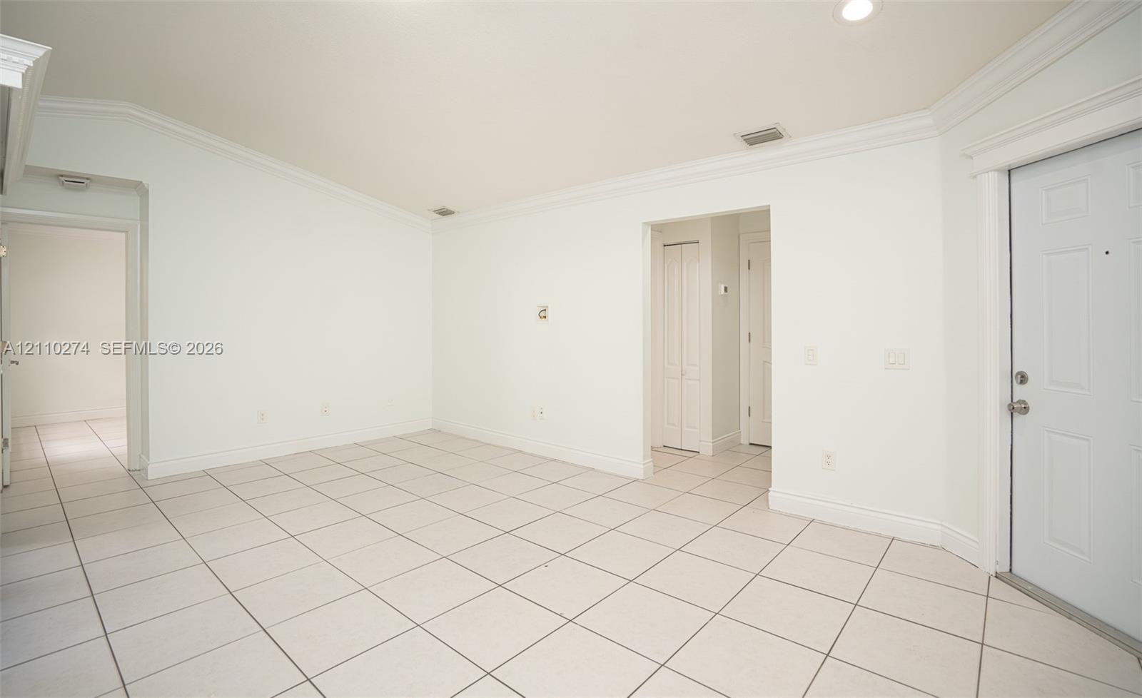 Interior room featuring neutral ceramic tile flooring, vaulted ceilings, recessed lighting, and crown molding