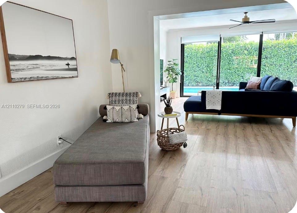 Wood-finish flooring throughout, sliding glass doors, and a ceiling fan