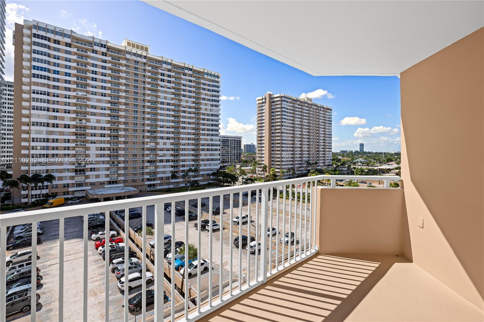 Covered balcony featuring white vertical railings and concrete flooring Covered balcony featuring white vertical railings and concrete flooring