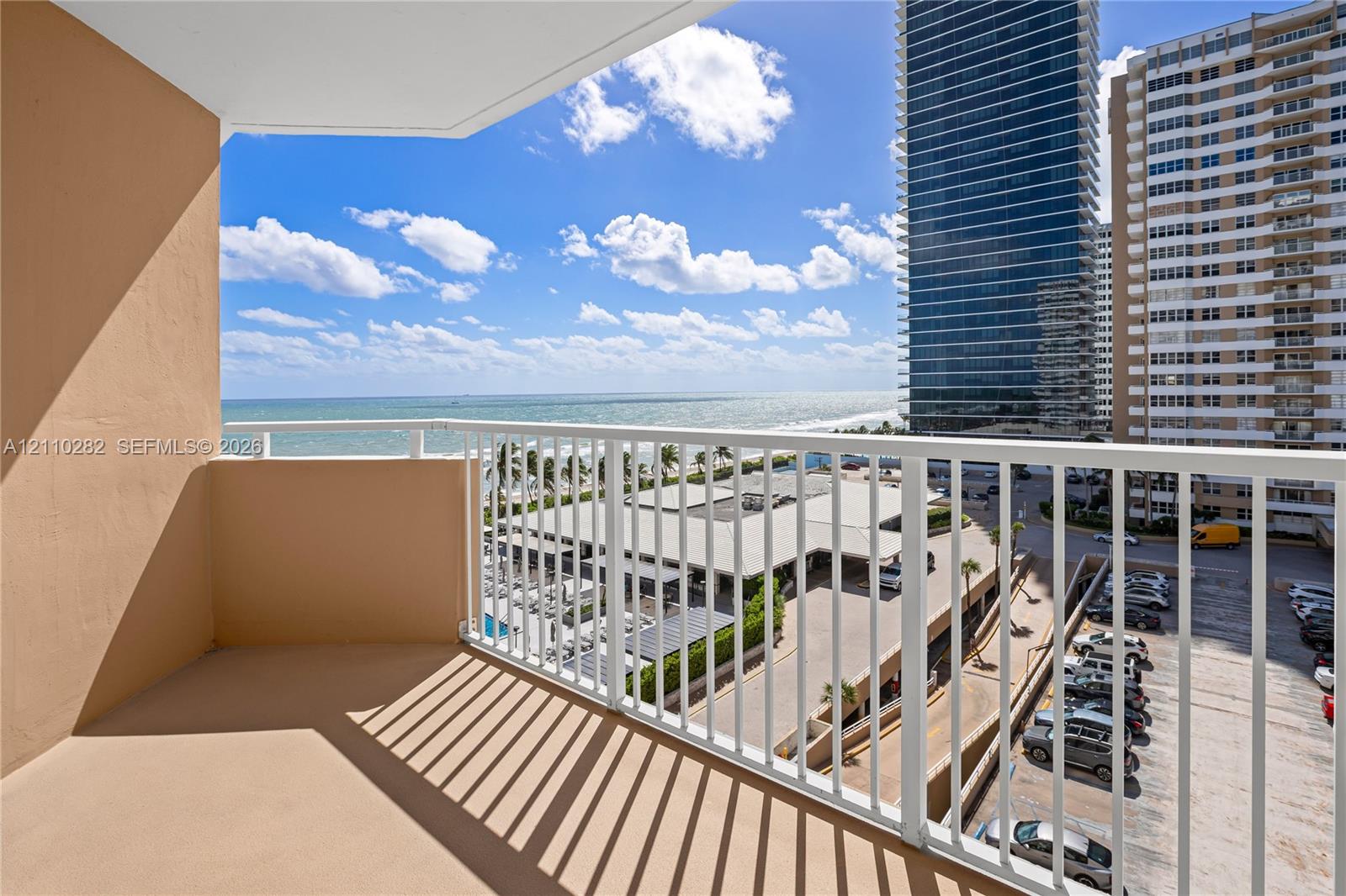 Private balcony featuring a white metal railing and solid concrete flooring Private balcony featuring a white metal railing and solid concrete flooring