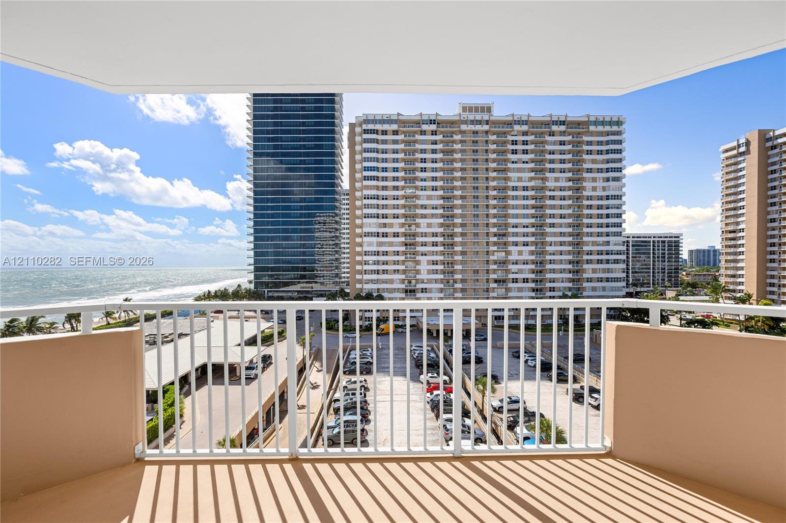 Covered balcony with white metal railings and concrete flooring Covered balcony with white metal railings and concrete flooring