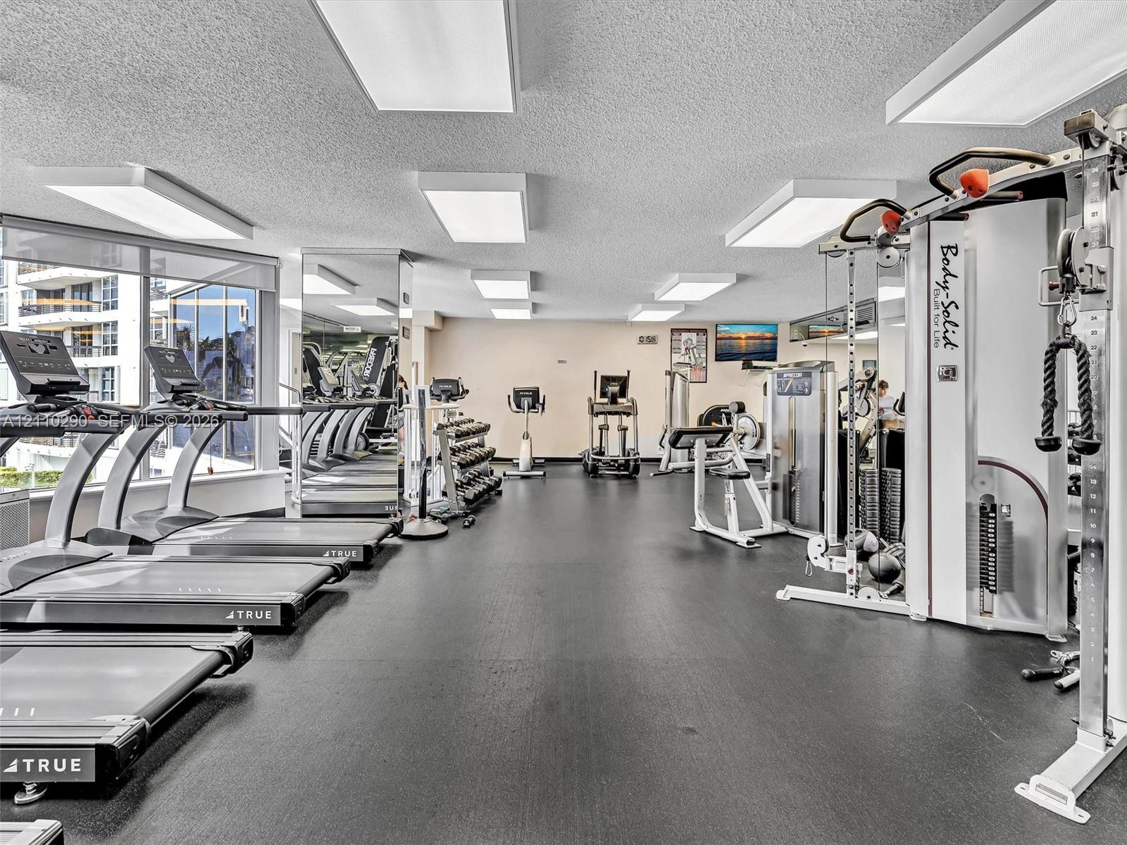 Fully Equipped Fitness Center Featuring a Reception Area, Spa, Extensive Exercise Equipment, and Dedicated Pilates Room