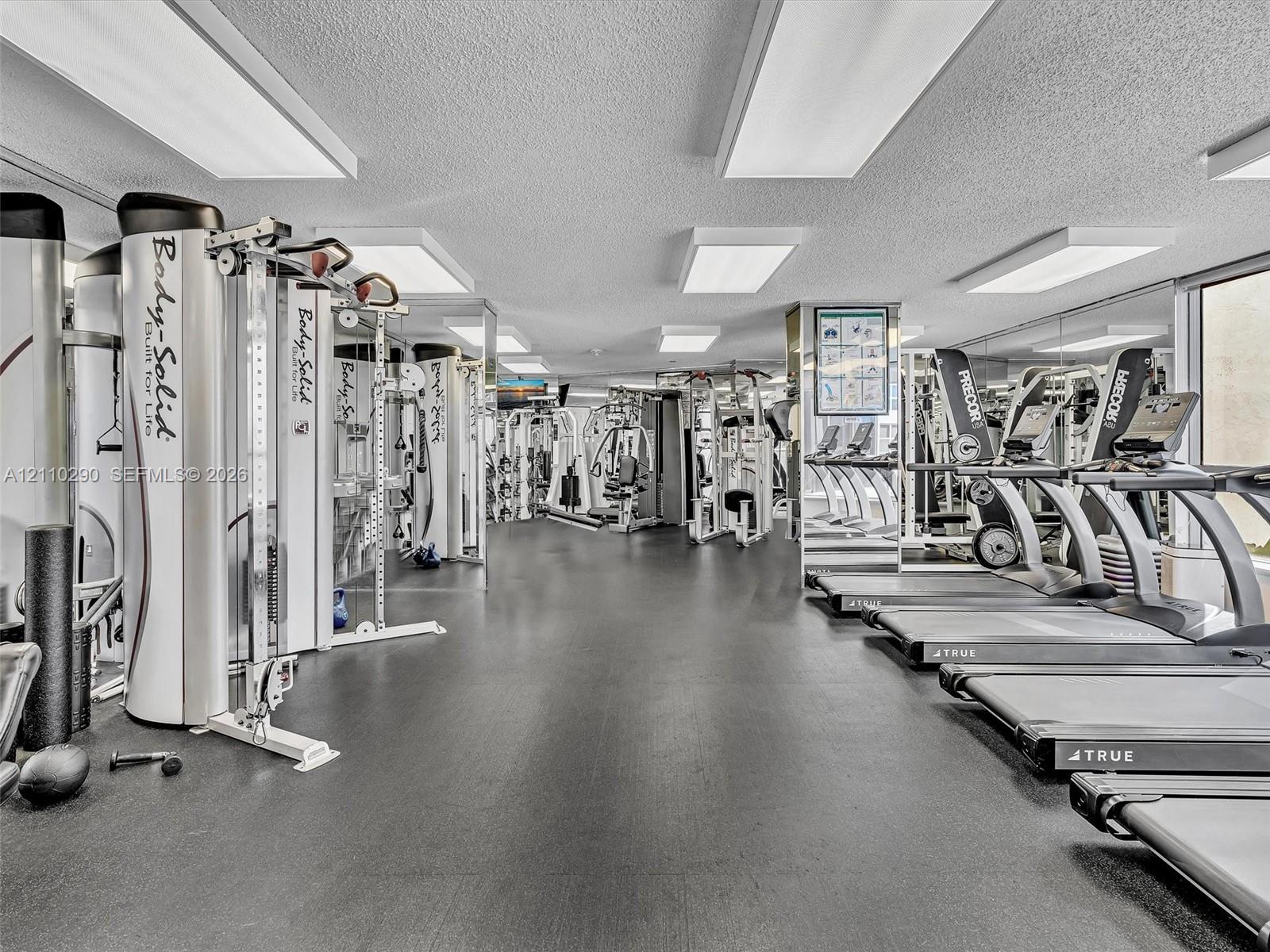 Fully Equipped Fitness Center Featuring a Reception Area, Spa, Extensive Exercise Equipment, and Dedicated Pilates Room