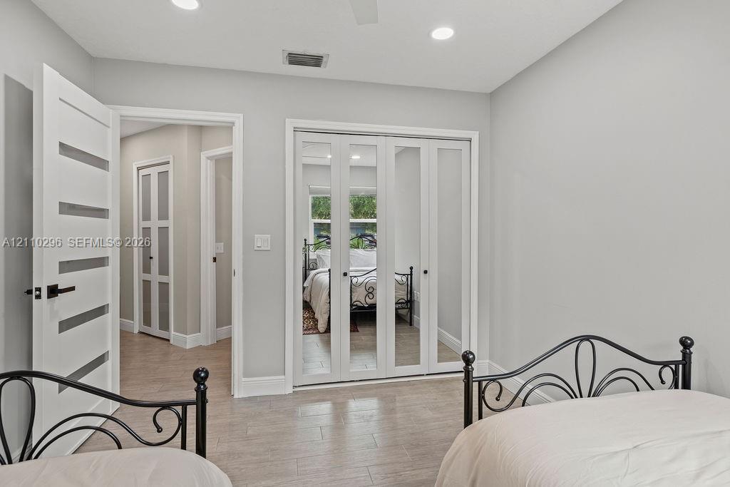 Room featuring wood-finish flooring, recessed lighting, and a multi-panel door with horizontal glass inserts