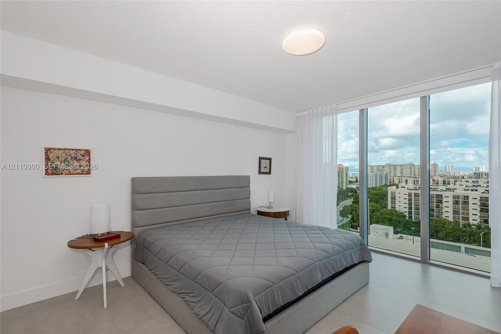 Master Bedroom. Floor-to-ceiling windows, neutral tile flooring, and flush-mount lighting