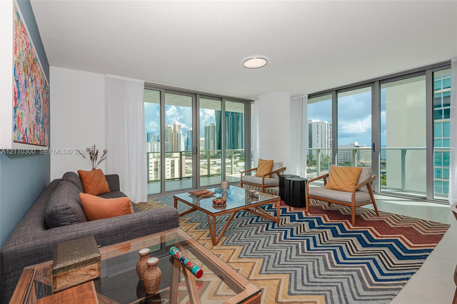 Floor-to-ceiling glass windows, wraparound balcony, neutral tile flooring, and recessed ceiling lighting