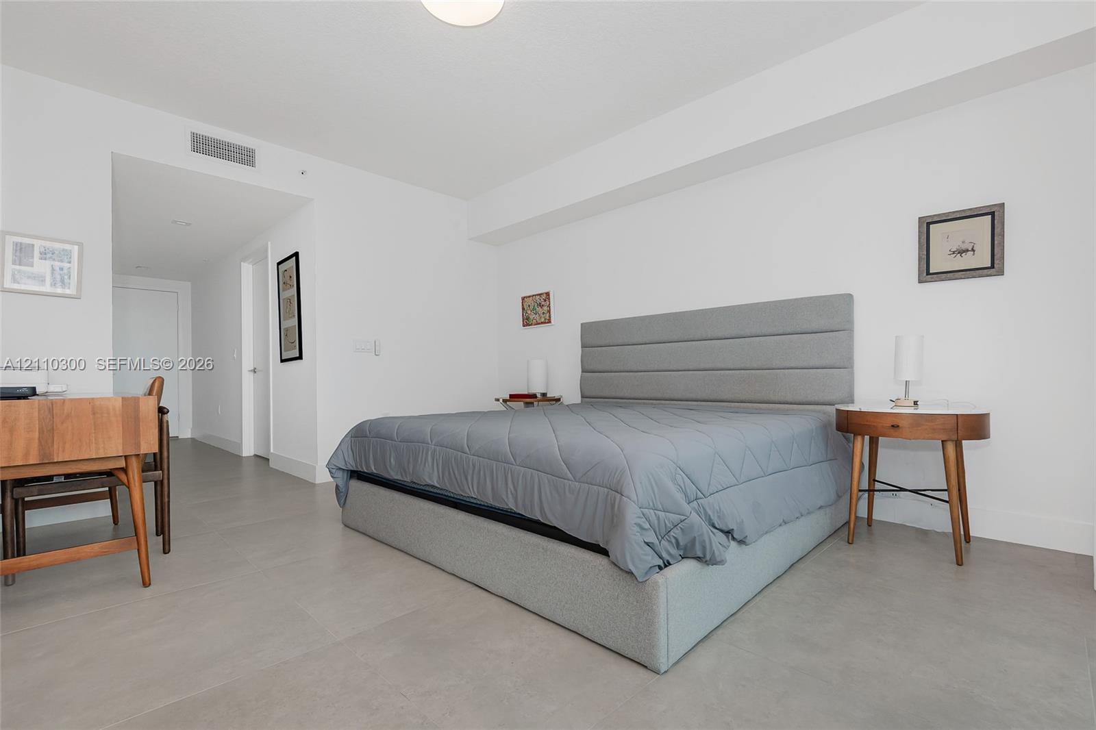 Master Bedroom. Neutral-toned large-format tile flooring, high ceilings, and recessed overhead lighting