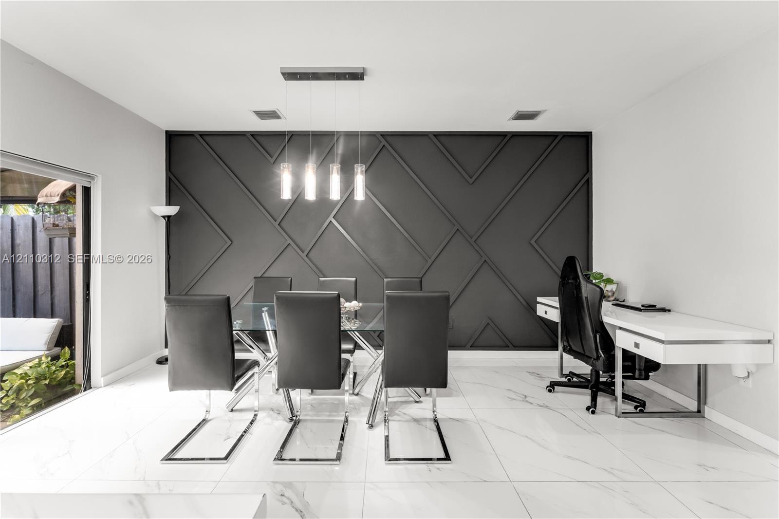 Geometric accent wall with matte black finish, large-format tile flooring, and four-light linear pendant fixture