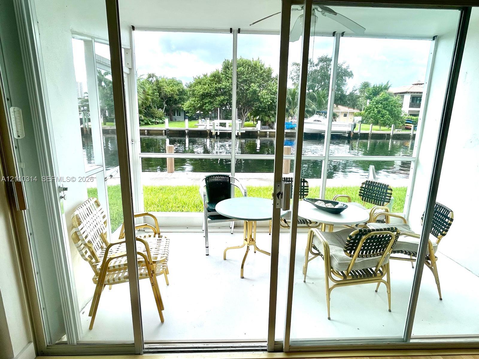 Screened-in patio featuring concrete flooring, ceiling fan, and direct water frontage with a bulkhead