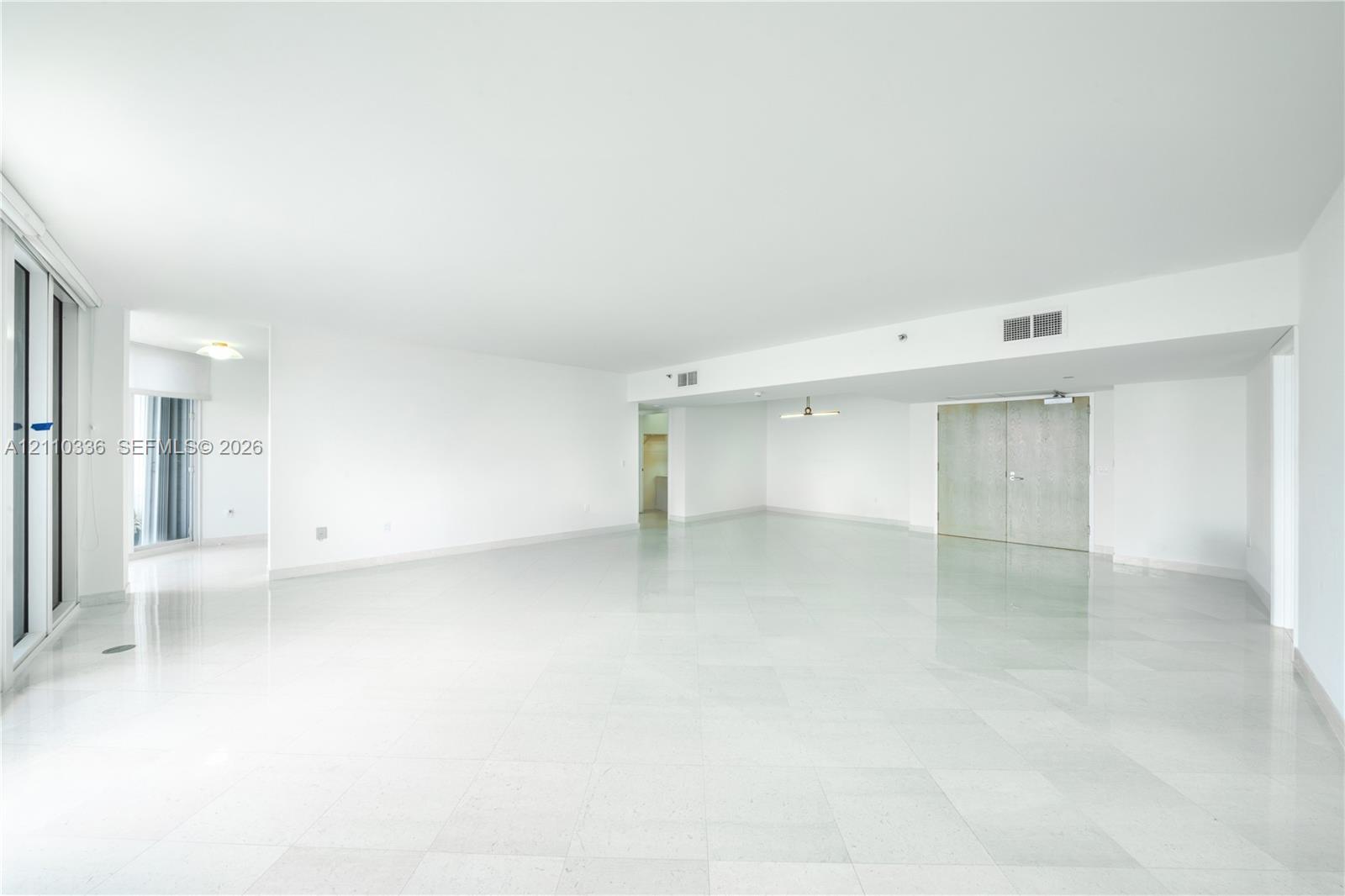Open-concept interior featuring polished tile flooring, smooth ceilings, recessed lighting, and double-door closet entry