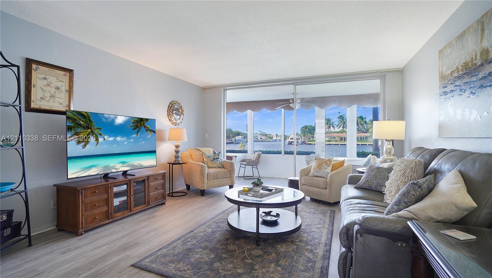 Living area featuring wood-finish flooring, expansive sliding glass doors, and water scenery