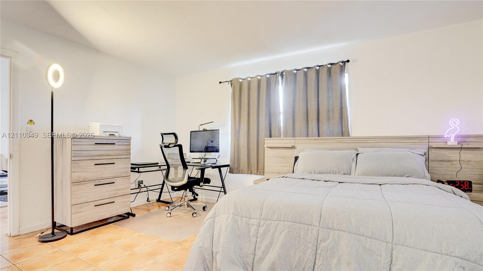 Room interior featuring tile flooring and a built-in wooden headboard with integrated side tables