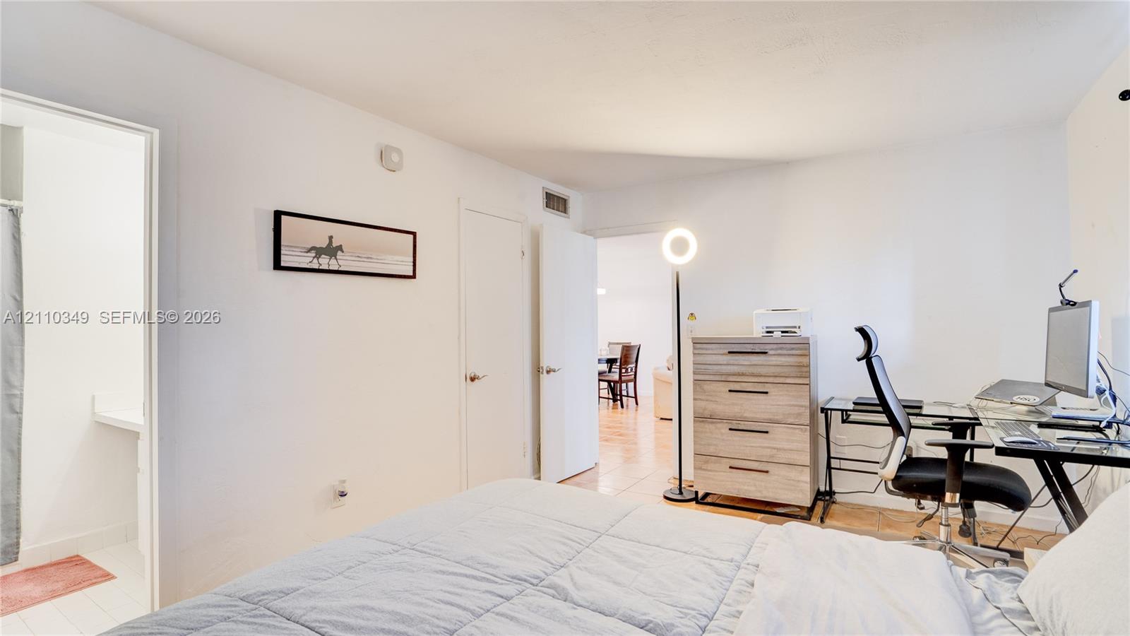 Neutral interior featuring smooth white wall finishes, wood-finish flooring, and multiple doorways with metallic hardware