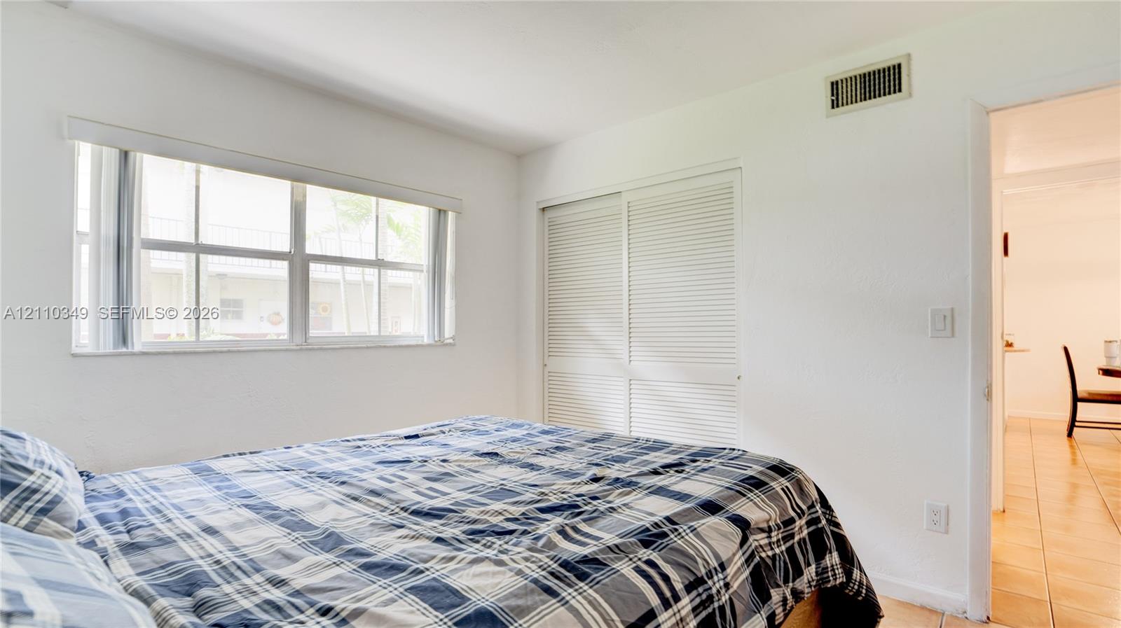 Bright room featuring large multi-pane windows and built-in closet storage with louvered doors