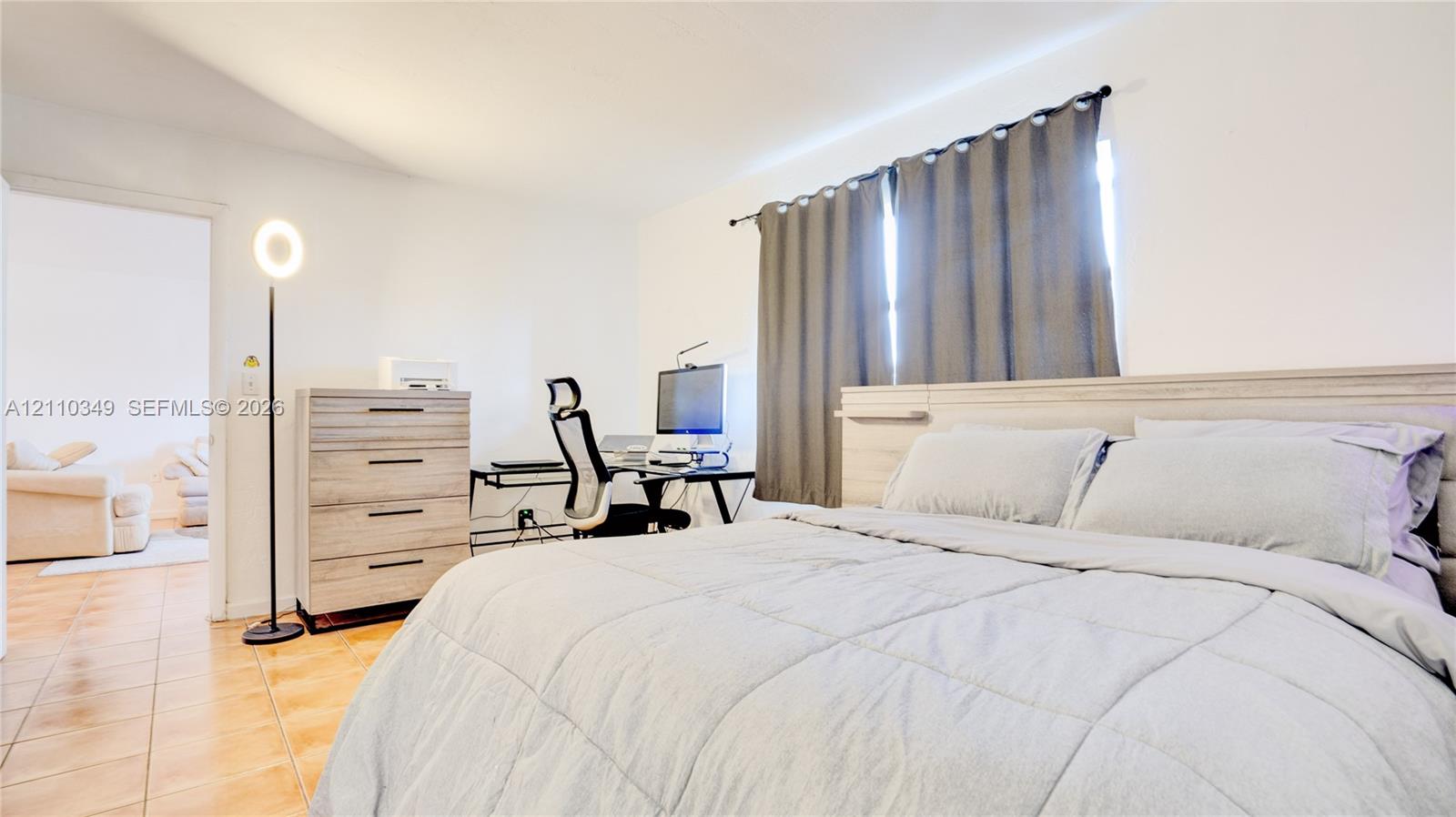 Room featuring neutral wall finishes, tile flooring, and a window with hardware for window treatments