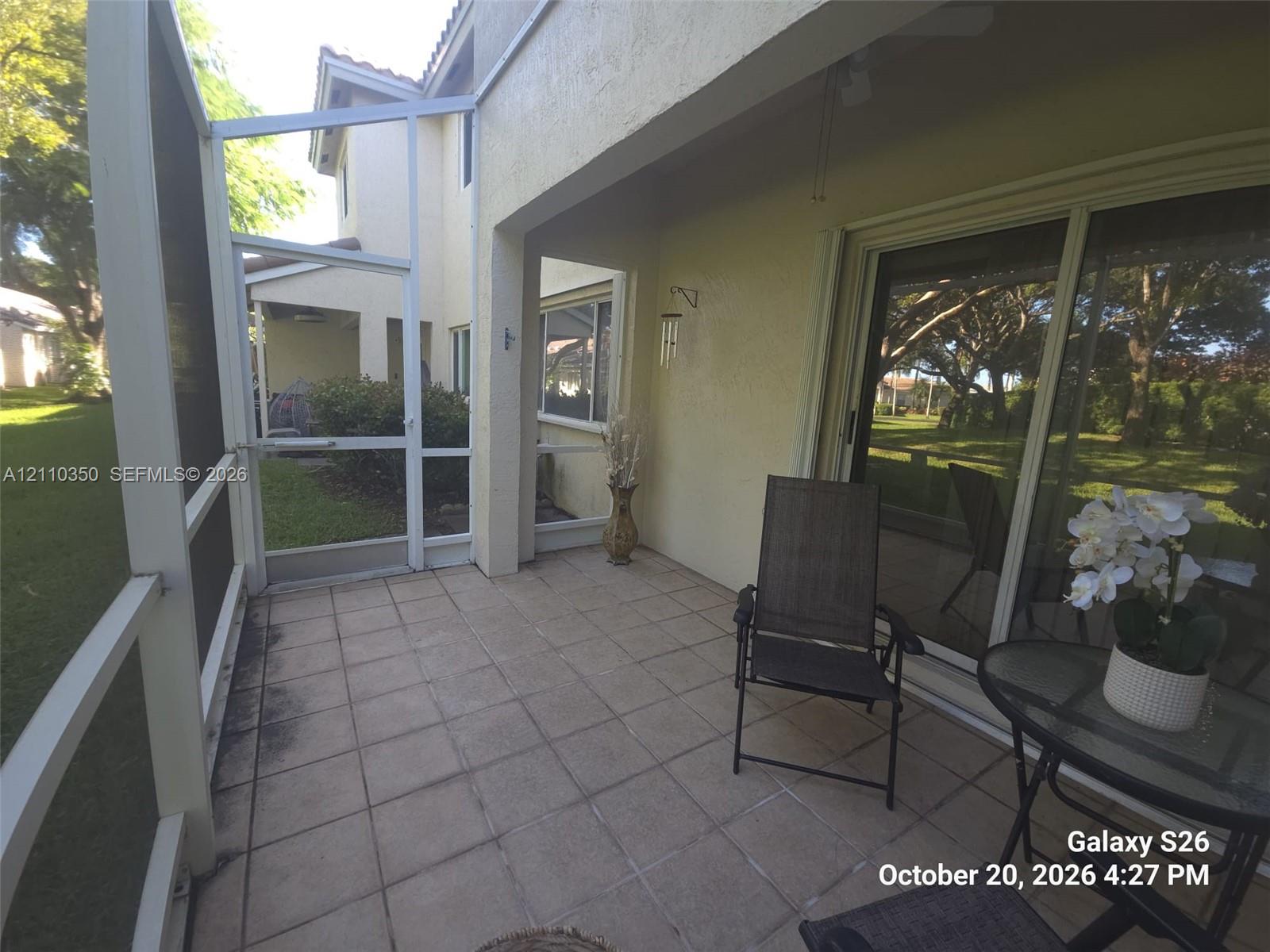 Screened lanai featuring tile flooring, a covered ceiling, and sliding glass entry doors