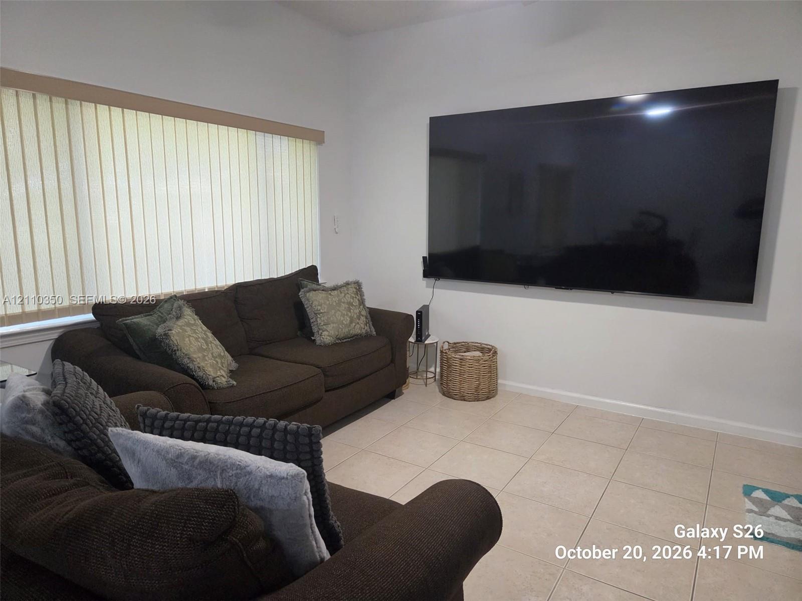 Neutral tile flooring and vertical window blinds Neutral tile flooring and vertical window blinds