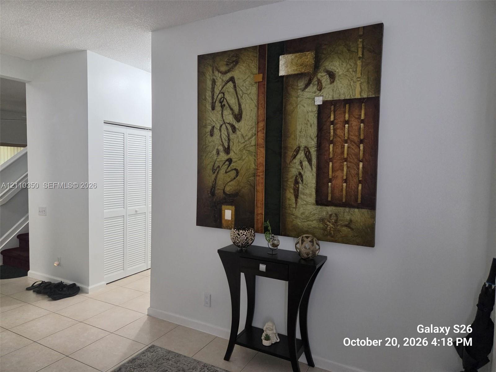 Neutral-toned tile flooring and double-panel louvered closet doors Neutral-toned tile flooring and double-panel louvered closet doors