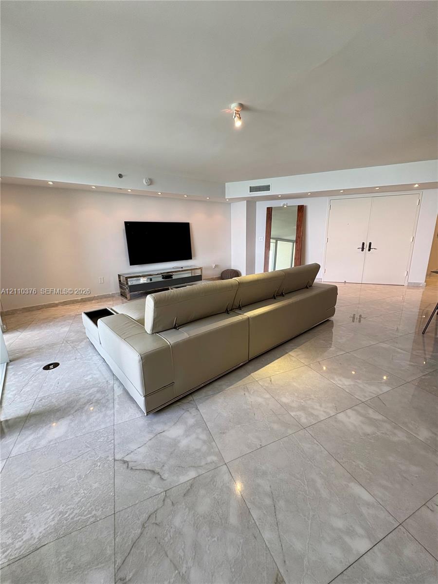Large-format stone tile flooring, recessed cove lighting, and double-entry doors Large-format stone tile flooring, recessed cove lighting, and double-entry doors