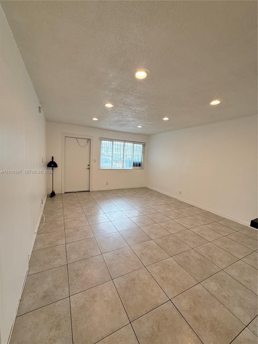 Neutral wall tones, ceramic tile flooring, and recessed ceiling lighting