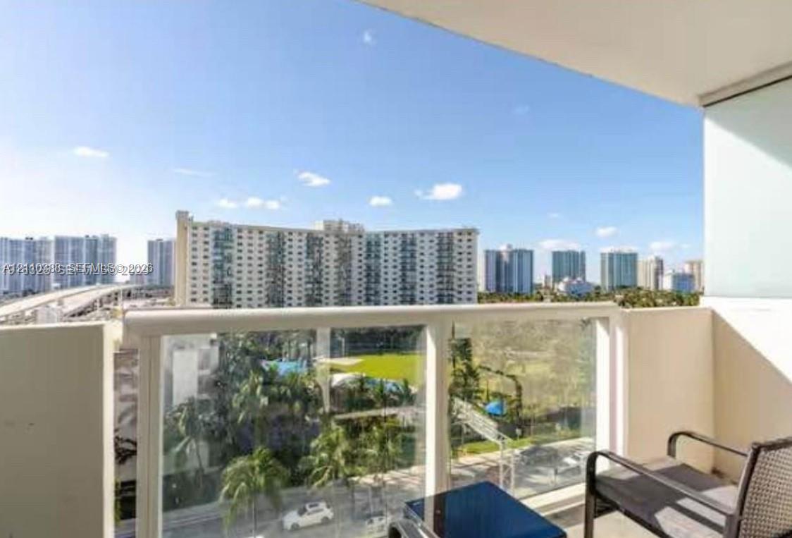 Private balcony featuring glass panel railing and urban skyscape Private balcony featuring glass panel railing and urban skyscape